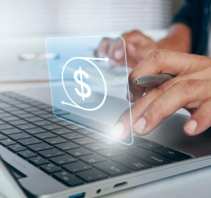 Close-up of hands using a laptop with a dollar sign graphic above the keyboard